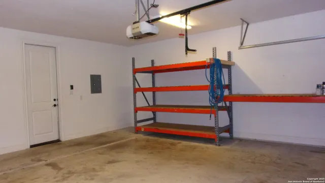 a view of an empty room with windows and ceiling fan