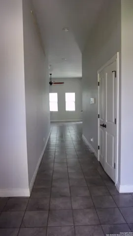 a view of a hallway with wooden floor and a living room