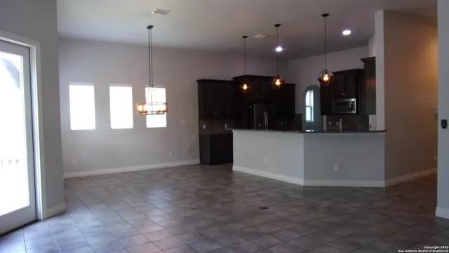 an open kitchen with a sink and chandelier