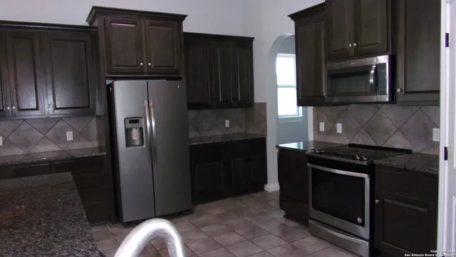 a kitchen with granite countertop stainless steel appliances and refrigerator