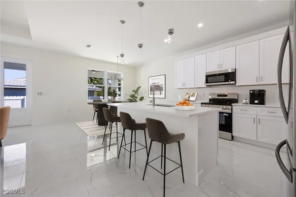 a kitchen with stainless steel appliances a sink stove refrigerator and cabinets