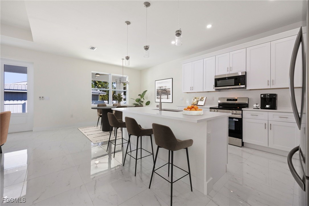 3002 Mercer Way LaBelle, FL 33935 - Photo 11 of 38 a kitchen with white cabinets and appliances