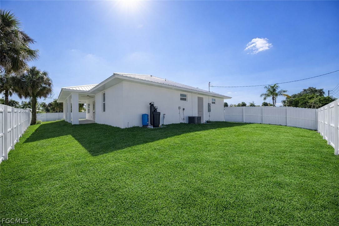 3002 Mercer Way LaBelle, FL 33935 - Photo 30 of 38 a view of a white house with a big yard and a large tree