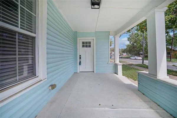 a view of a porch with furniture and floor to ceiling window