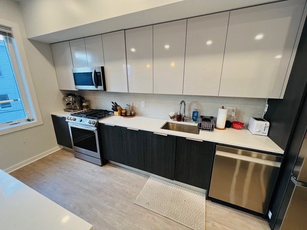 a kitchen with a sink a refrigerator and cabinets