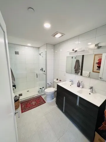 a bathroom with a double vanity sink mirror and shower