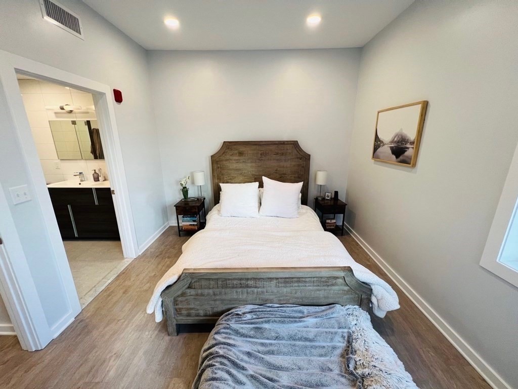14 Ward Street, Unit 102 Somerville, MA 02143 - Photo 5 of 10 a bedroom with a bed and wooden floor