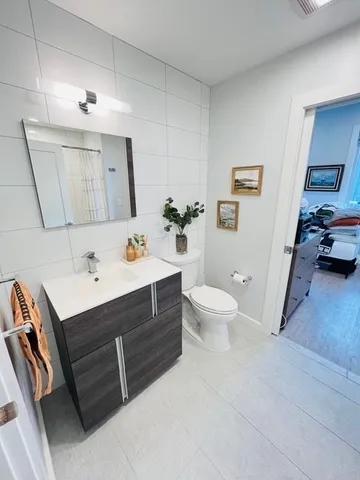 a bathroom with a sink vanity granite and toilet