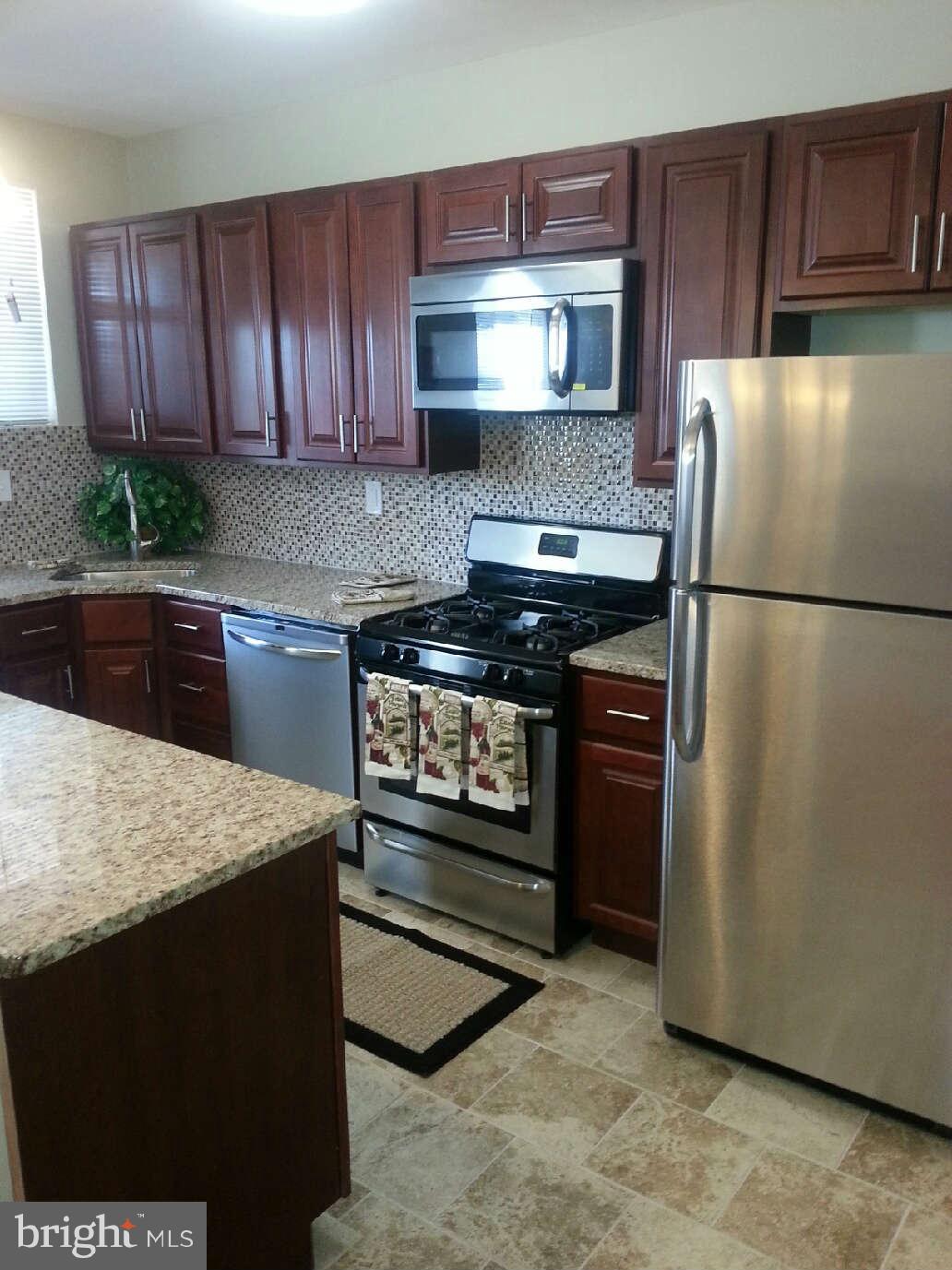 414 North Bend Road Baltimore, MD 21229 - Photo 17 of 27 a kitchen with stainless steel appliances granite countertop a refrigerator stove a sink dishwasher and microwave oven