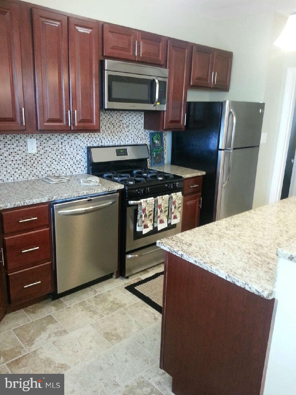 414 North Bend Road Baltimore, MD 21229 - Photo 4 of 27 a kitchen with stainless steel appliances granite countertop a stove a refrigerator and a microwave