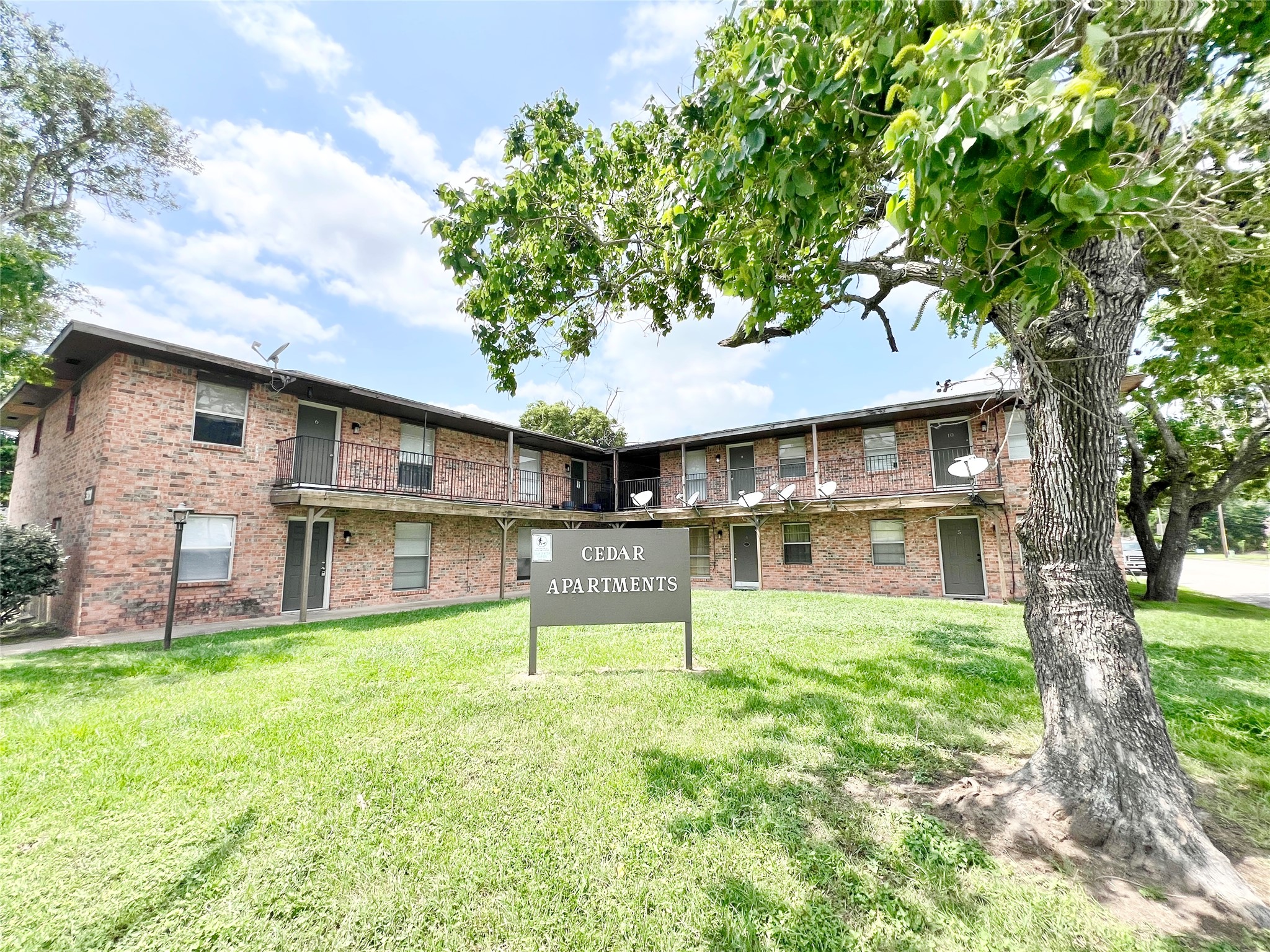 321 East Cedar Street, Unit 7 Angleton, TX 77515 - Photo 1 of 16 a front view of a house with a yard table and chairs