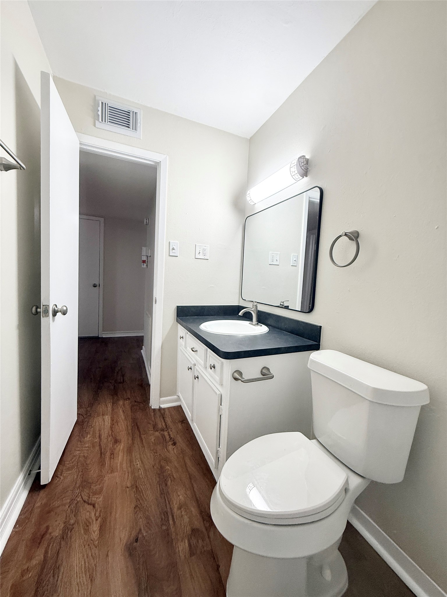 321 East Cedar Street, Unit 7 Angleton, TX 77515 - Photo 14 of 16 a bathroom with a toilet sink and mirror