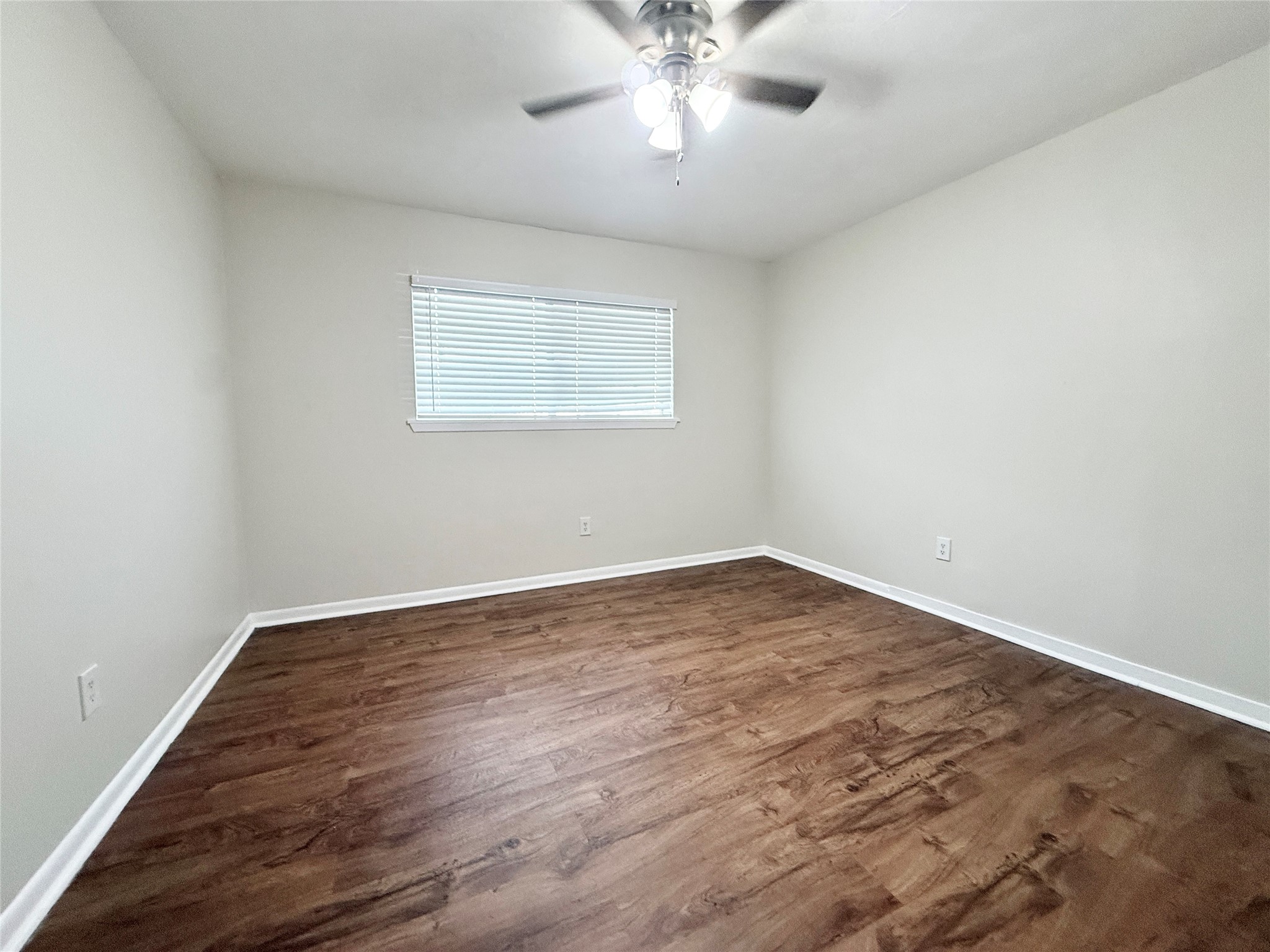 321 East Cedar Street, Unit 7 Angleton, TX 77515 - Photo 15 of 16 wooden floor in an empty room with a window