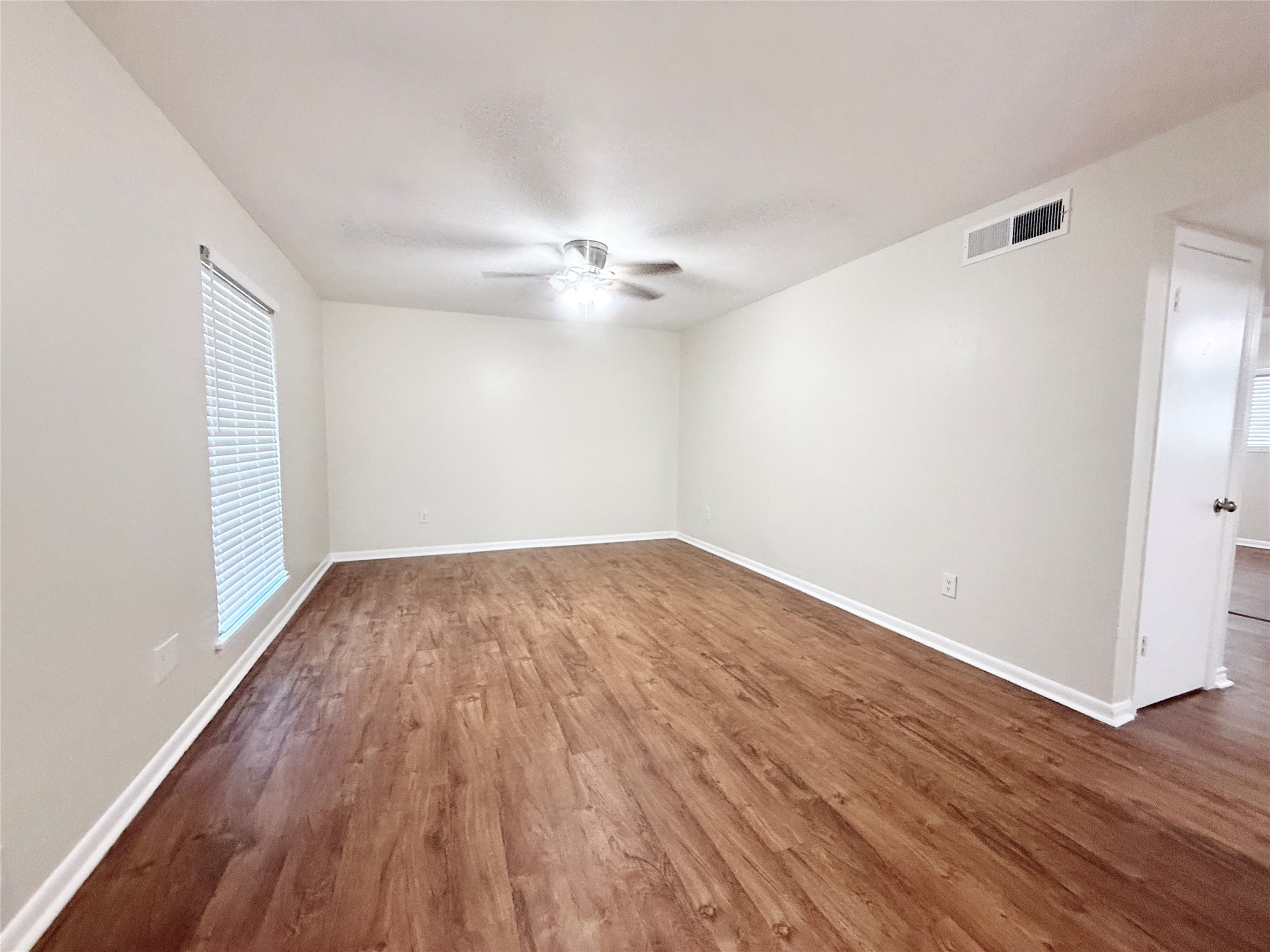 321 East Cedar Street, Unit 7 Angleton, TX 77515 - Photo 2 of 16 wooden floor in an empty room with a window