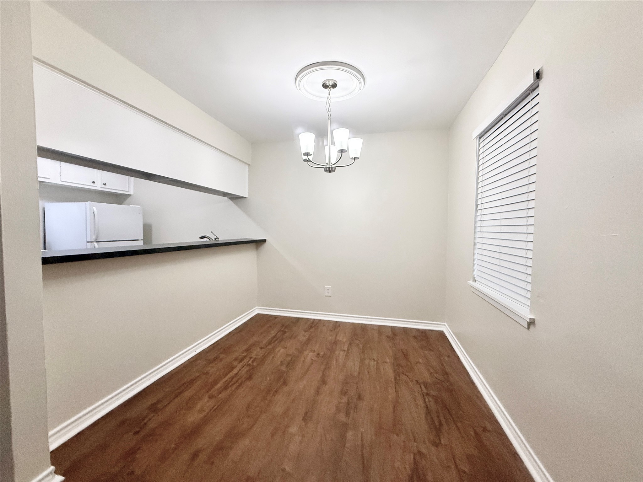 321 East Cedar Street, Unit 7 Angleton, TX 77515 - Photo 4 of 16 wooden floor in an empty room with a window