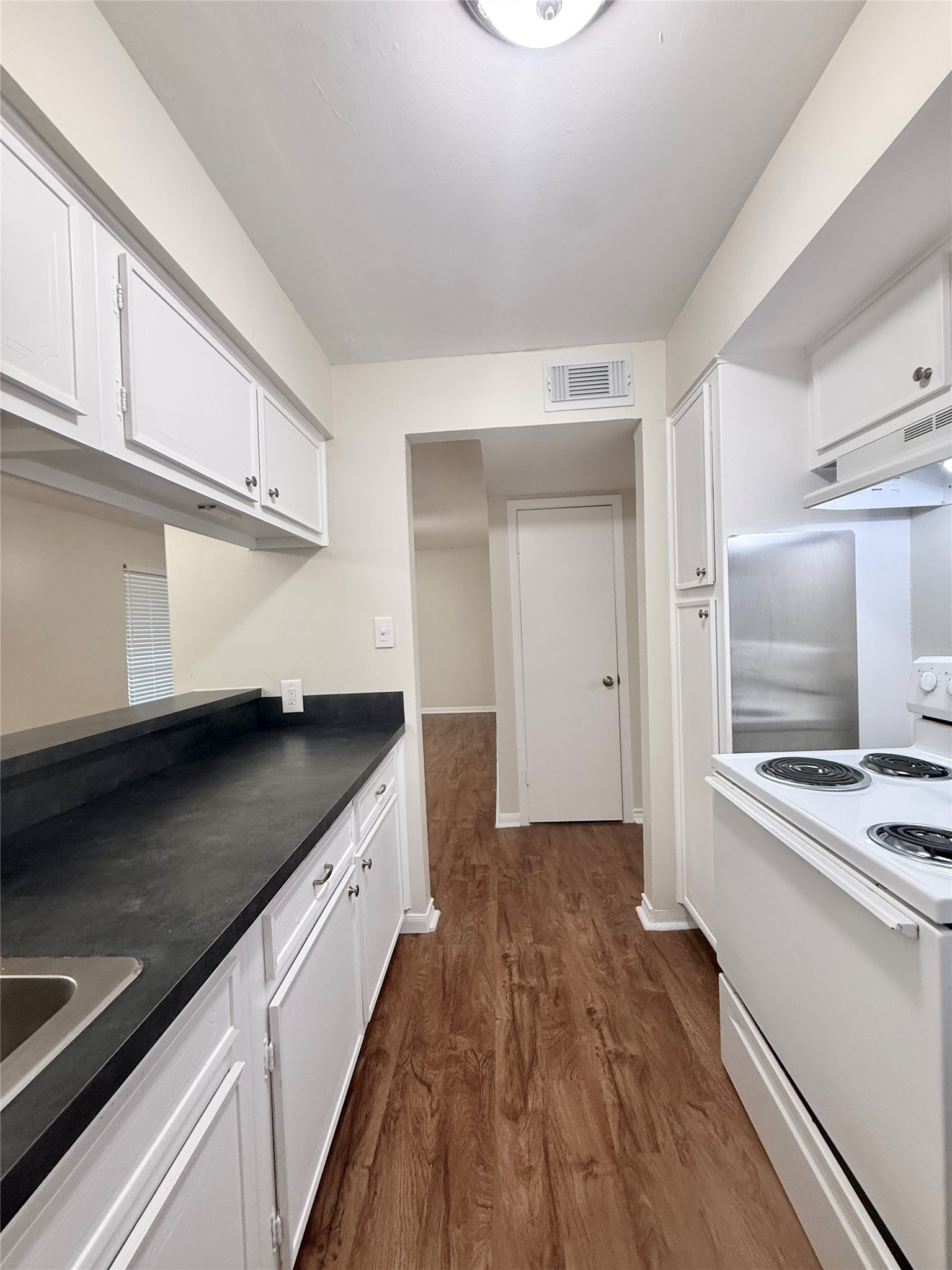 321 East Cedar Street, Unit 7 Angleton, TX 77515 - Photo 8 of 16 a kitchen with granite countertop a sink and a stove top oven
