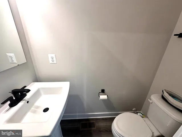 a bathroom with a sink a toilet and mirror