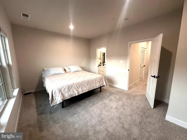 a bedroom with a bed and a large mirror