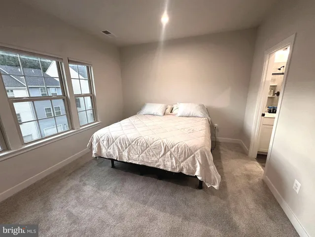 a bedroom with a bed and a large window