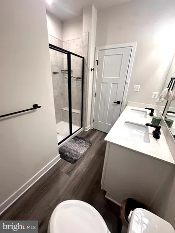a bathroom with a sink a toilet a mirror and shower