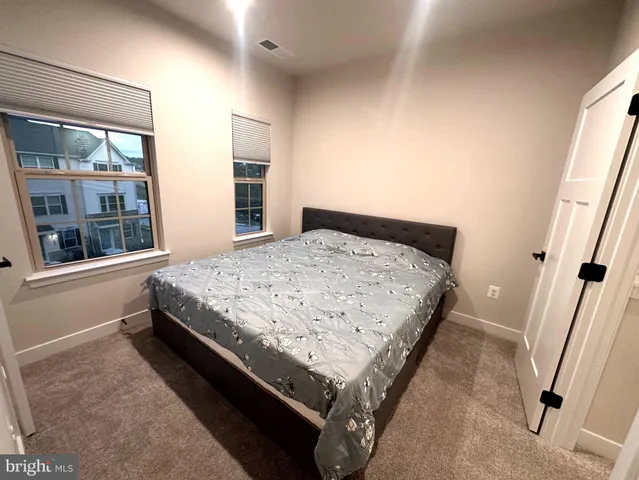 a bedroom with a bed and a large window