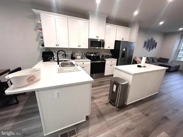 a kitchen with a sink a counter top space and stainless steel appliances
