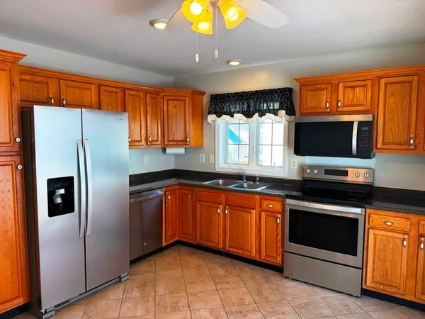 a kitchen with stainless steel appliances granite countertop a refrigerator and a sink
