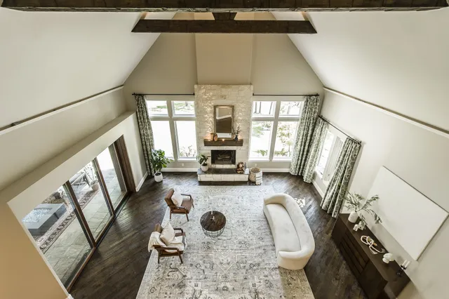 a front door with couches chair and a stove with wooden floor