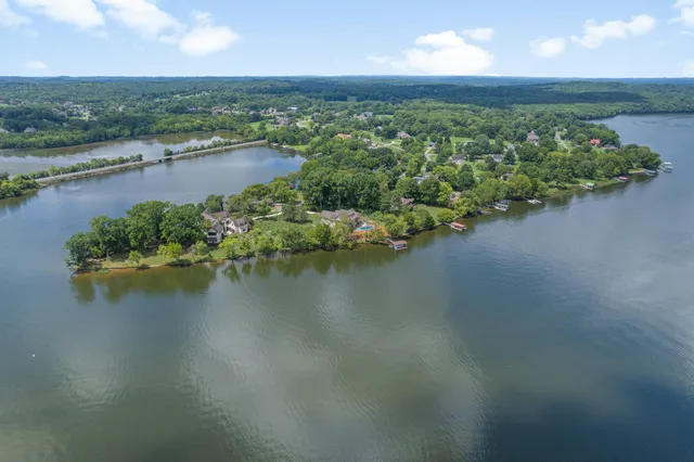 an aerial view of ocean with residential house with outdoor space and trees around