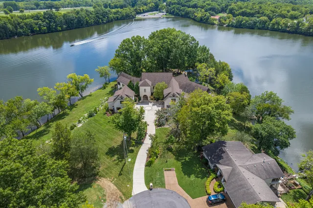 an aerial view of a house with a yard and lake view