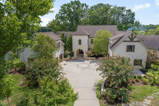 a view of house with a yard and fountain in middle
