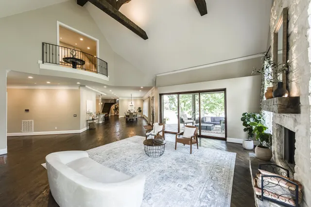 a living room with furniture large window and wooden floor