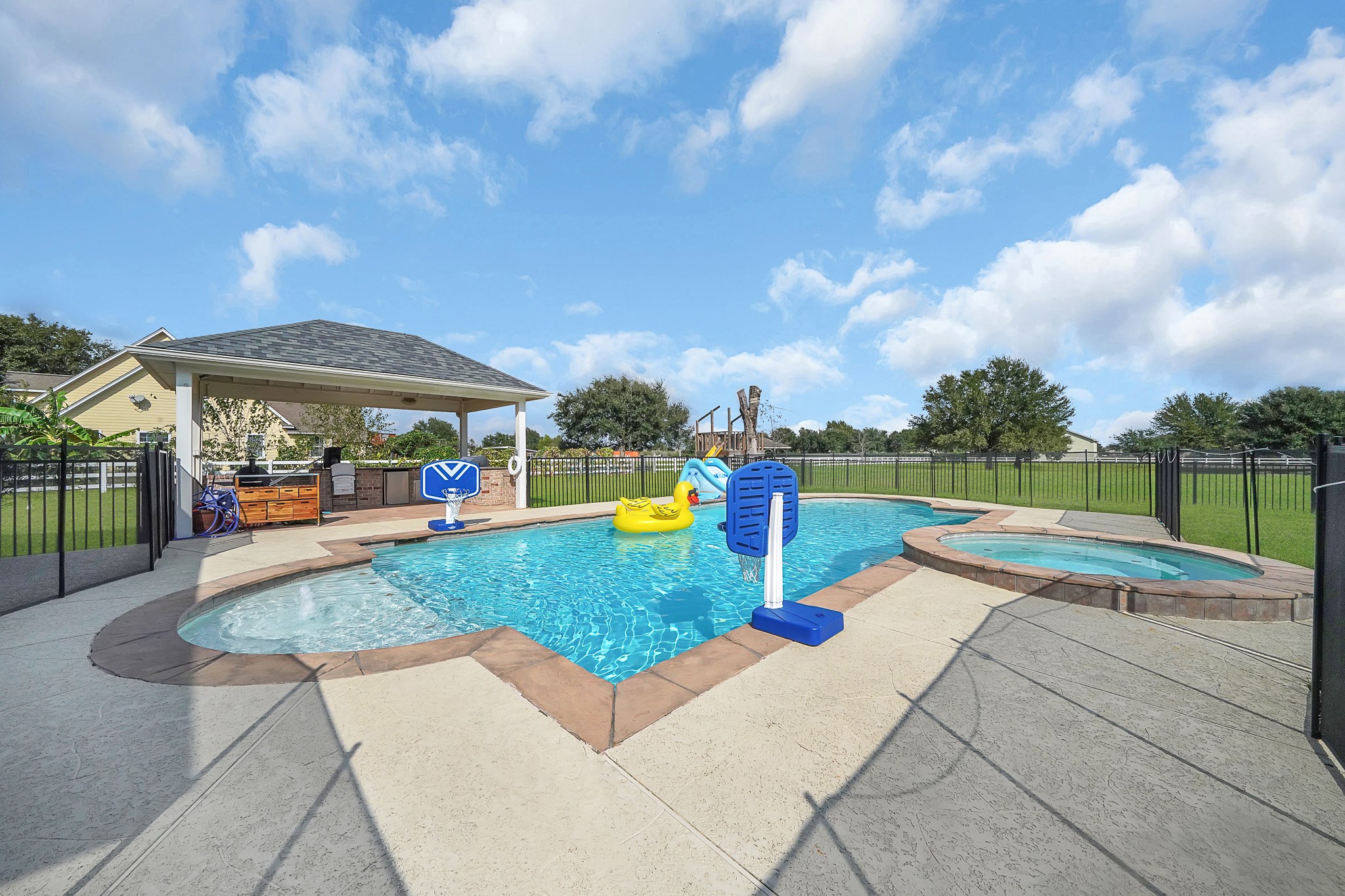 4730 Pitts Road Katy, TX 77493 - Photo 23 of 36 Enjoy a luxurious spa on an expansive deck with a view of the sophisticated outdoor kitchen, perfect for entertaining.