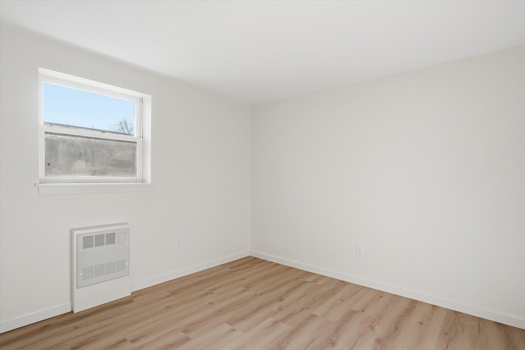237 Main Street, Unit A4 Reading, MA 01867 - Photo 11 of 22 a view of an empty room with wooden floor and a window