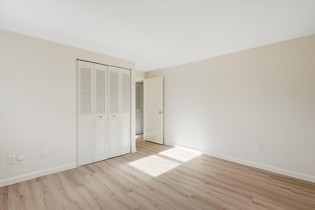 237 Main Street, Unit A4 Reading, MA 01867 - Photo 16 of 22 a view of an empty room with wooden floor