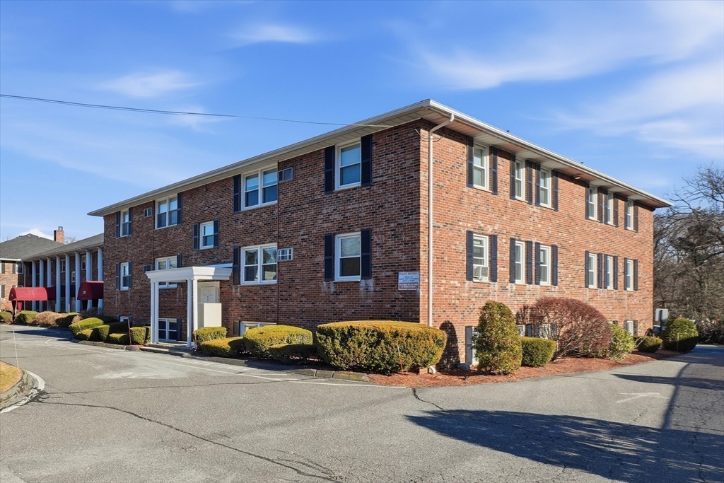237 Main Street, Unit A4 Reading, MA 01867 - Photo 20 of 22 a front view of a building with cars parked in front of it