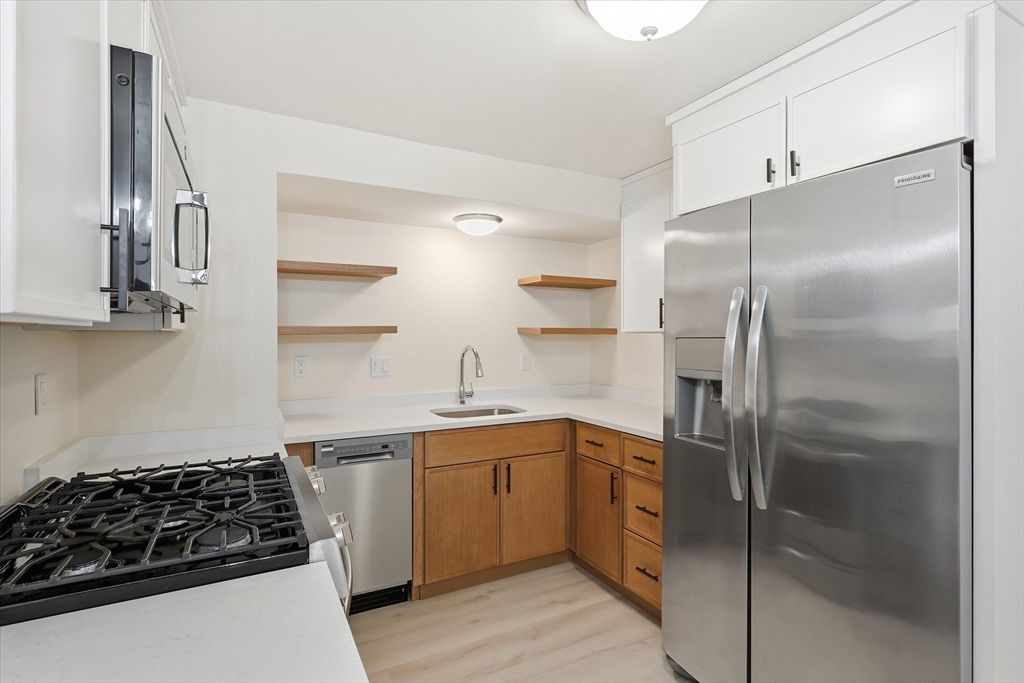 237 Main Street, Unit A4 Reading, MA 01867 - Photo 2 of 22 a kitchen with stainless steel appliances a refrigerator and a sink