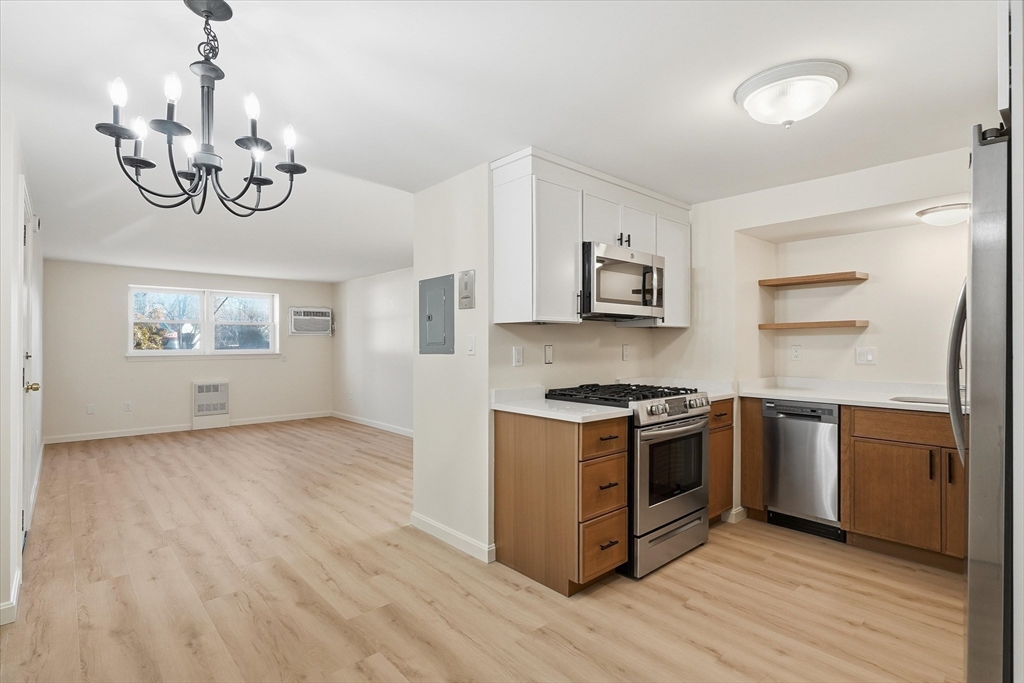 237 Main Street, Unit A4 Reading, MA 01867 - Photo 4 of 22 a kitchen with stainless steel appliances granite countertop a wooden cabinets a stove a sink and dishwasher