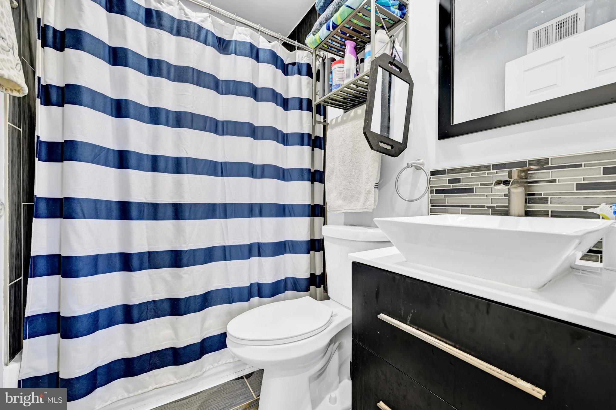 1401 East Lanvale Street Baltimore, MD 21213 - Photo 11 of 17 a bathroom with a sink a toilet and shower