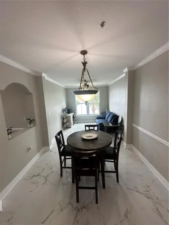 a living room with couches and kitchen view with wooden floor
