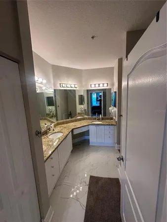 a bathroom with a granite countertop sink toilet and mirror