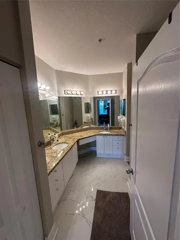 a bathroom with a granite countertop sink toilet and mirror