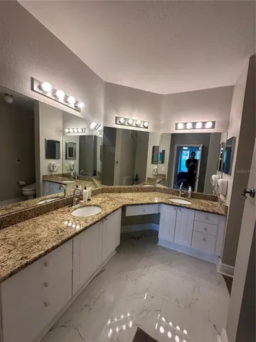 a bathroom with a granite countertop sink a large mirror and a bathtub