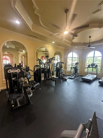 a front view of a building with a garden and palm trees