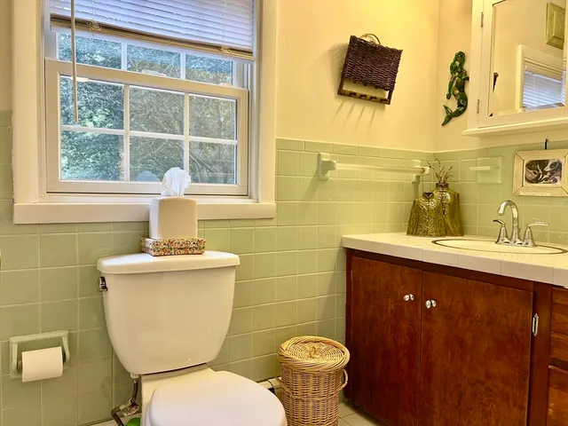 a bathroom with a toilet sink and mirror