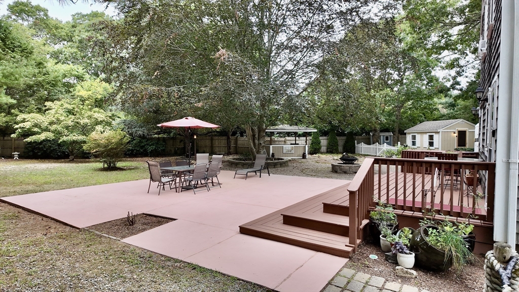 19 Rolling Acres Lane Falmouth, MA 02536 - Photo 18 of 27 a view of a patio with a table chairs and a barbeque