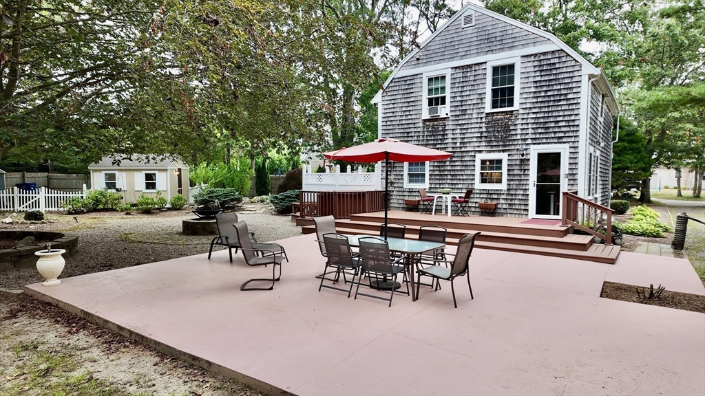 19 Rolling Acres Lane Falmouth, MA 02536 - Photo 19 of 27 a view of a patio with table and chairs under an umbrella