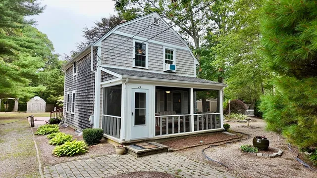 a view of a small house with yard and floor to ceiling window