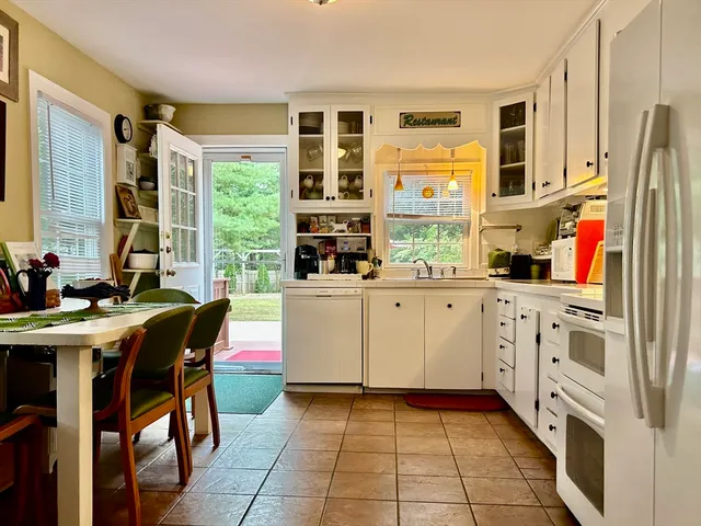 a kitchen with stainless steel appliances kitchen island granite countertop a table and chairs in it