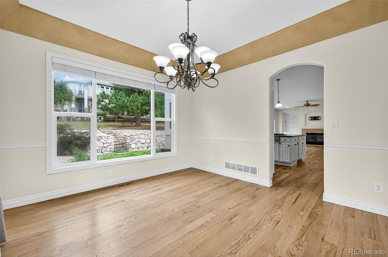 8389 Owl Roost Court Parker, CO 80134 - Photo 20 of 50 a view of an empty room with a window and wooden floor
